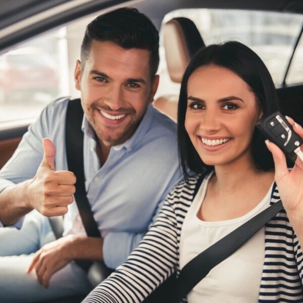 A man and woman sitting in the back of a car.